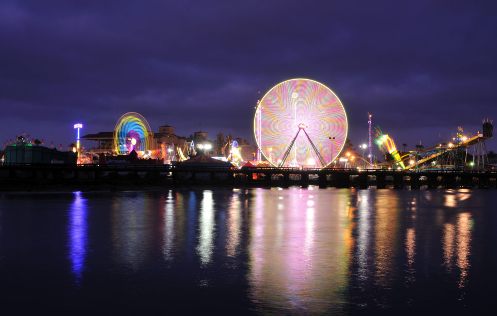 Fair rides at night in front of the ocean