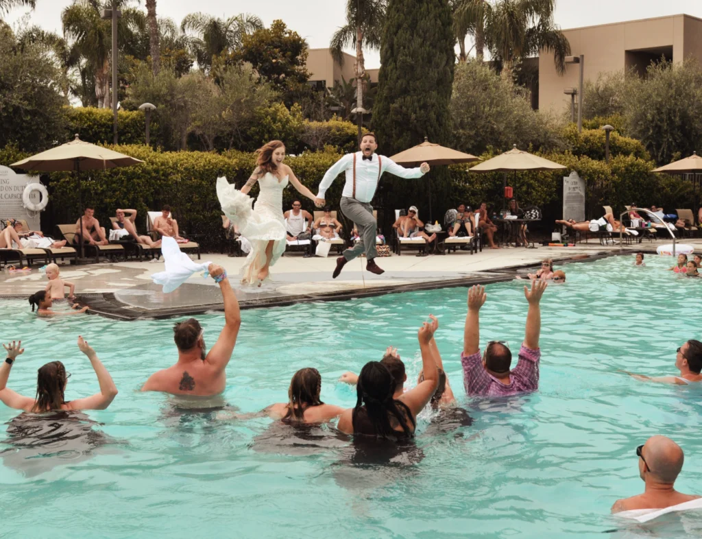 married couple jumping in pool