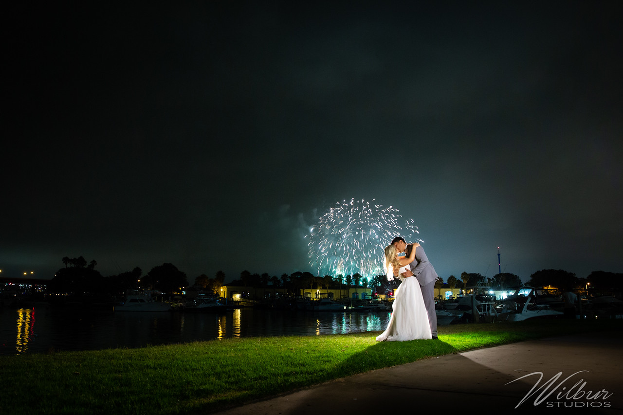 Couple kisses in front of fireworks over the water