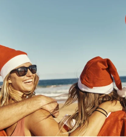 friends on the beach with Santa hats