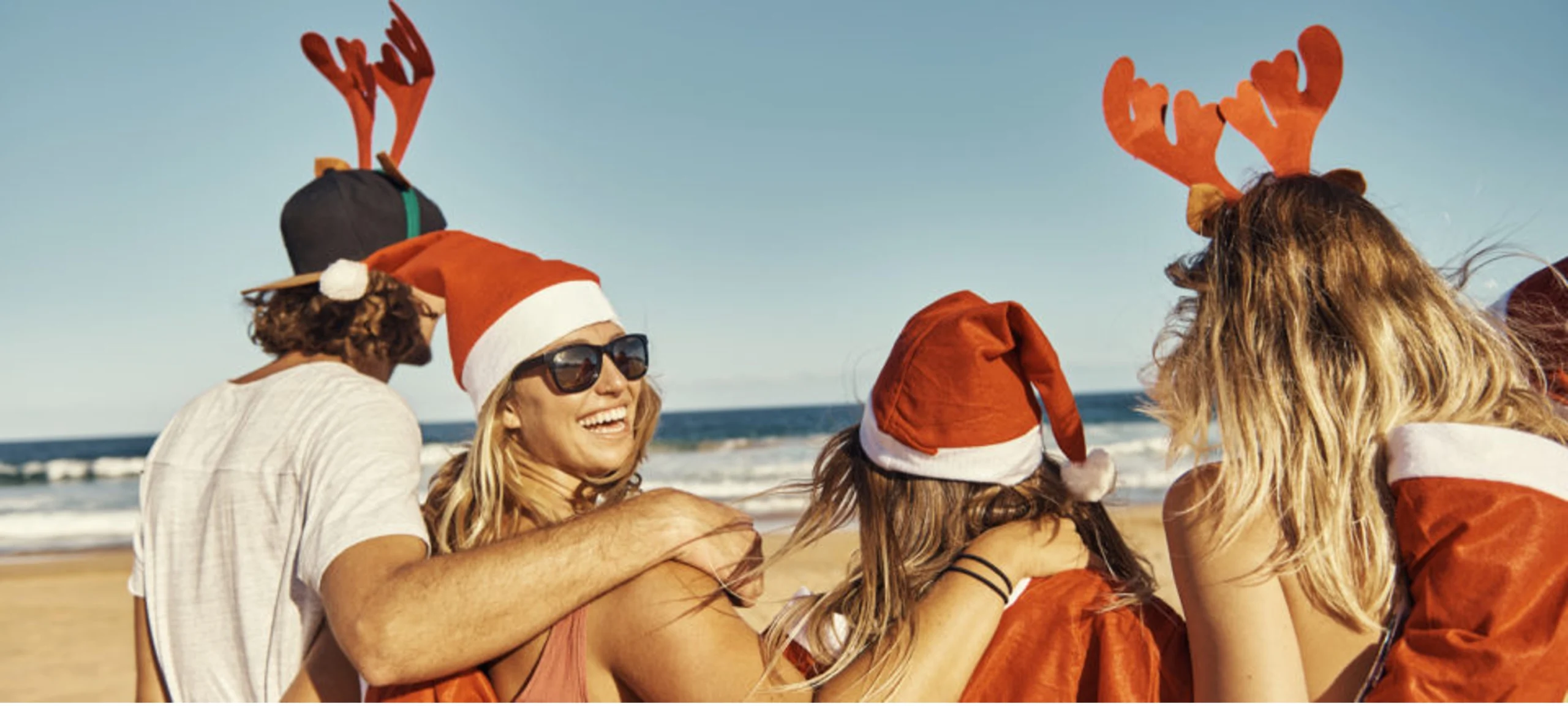 friends on the beach with Santa hats