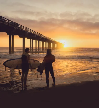 two surfers at sunset at the beach