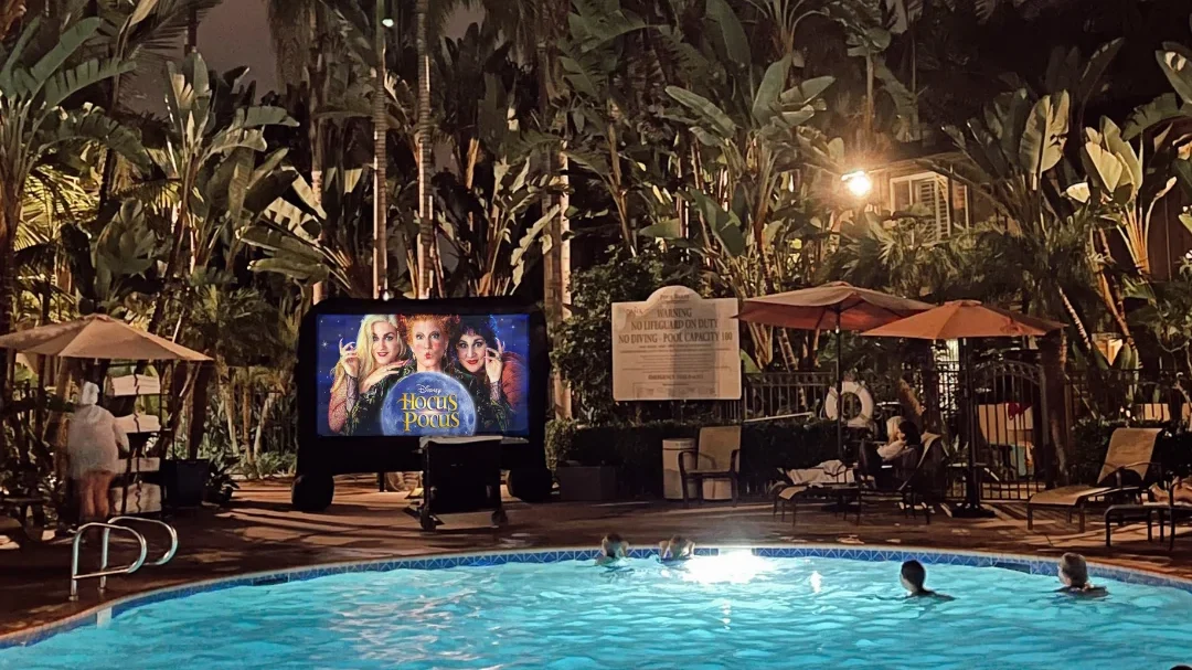 movie by the pool with a large full moon in the background