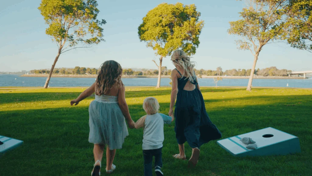 Family running on lawn in front of mission bay