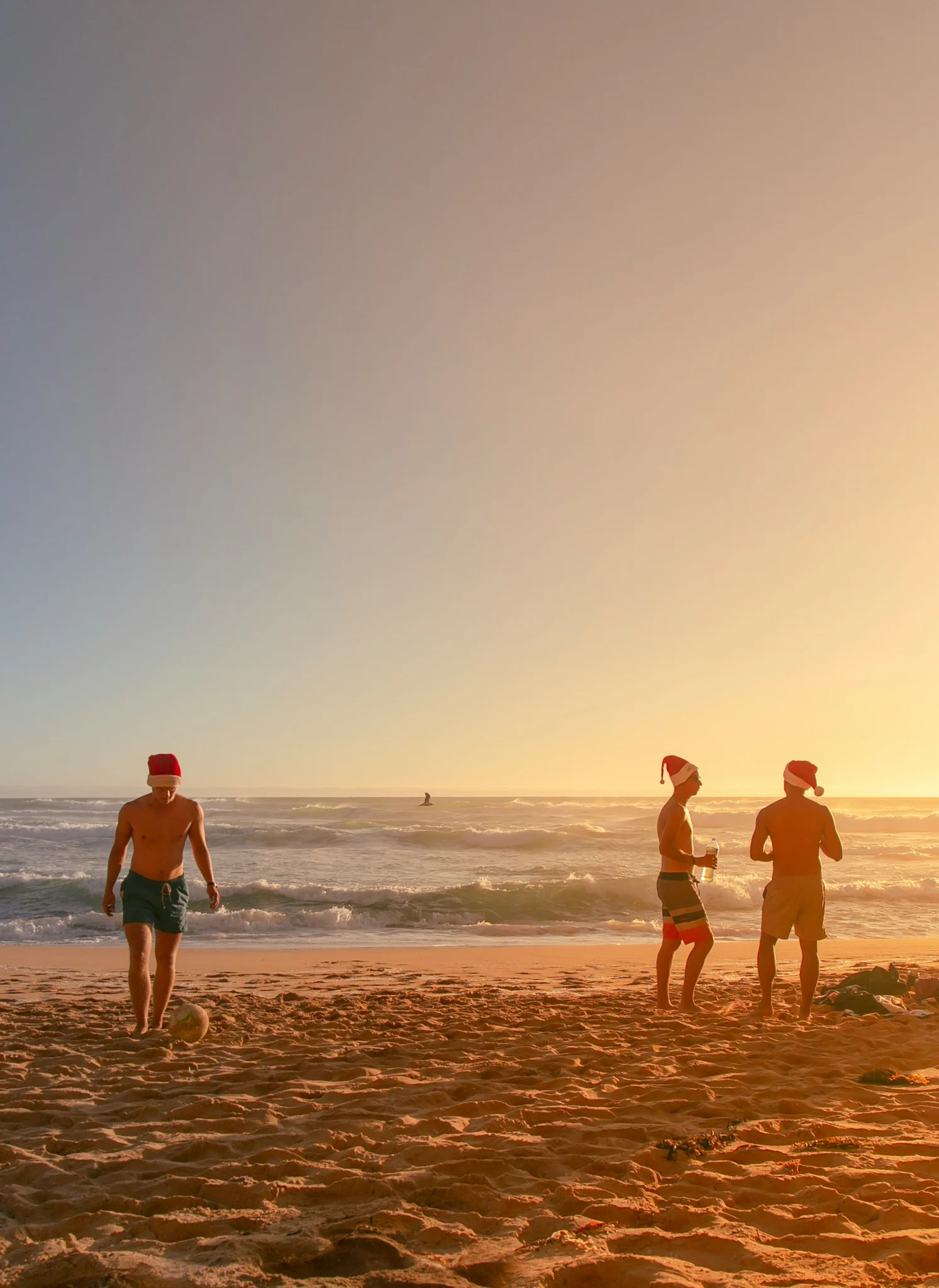people in santa hats on beach