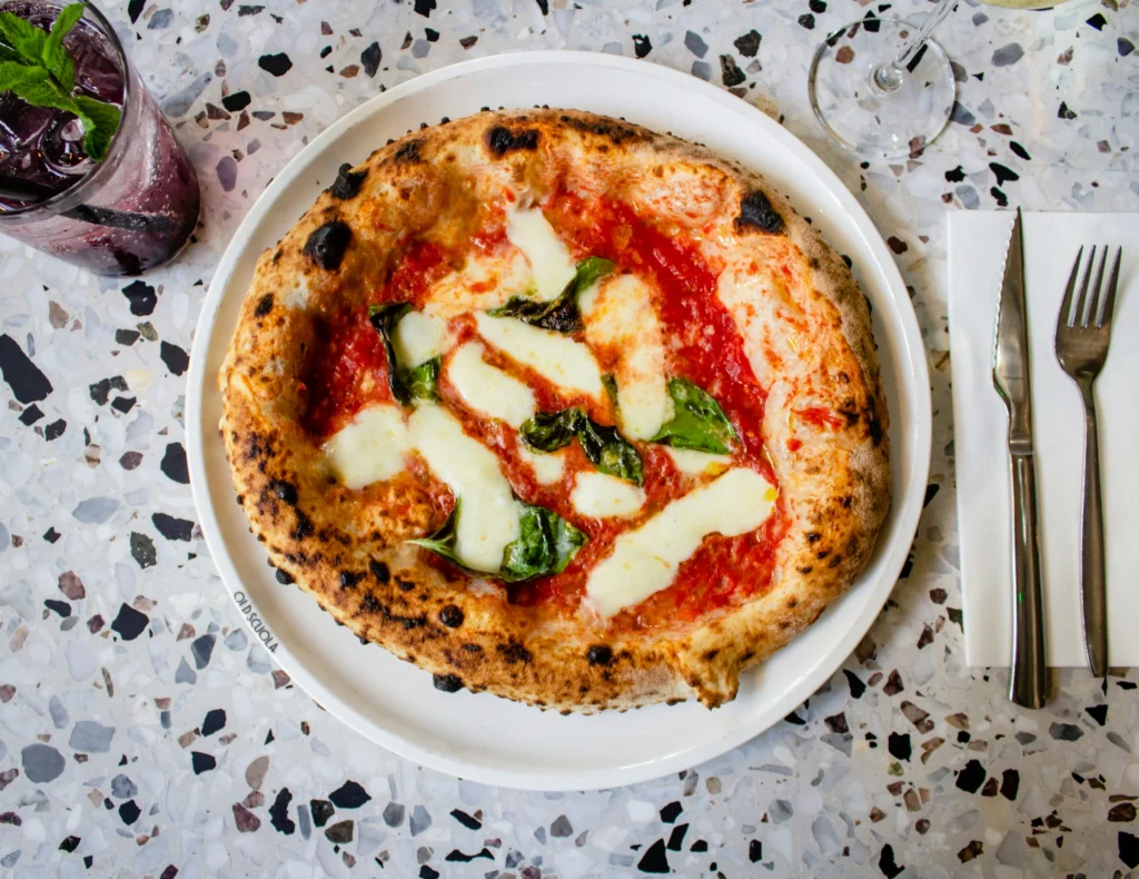 A pizza margherita with drinks