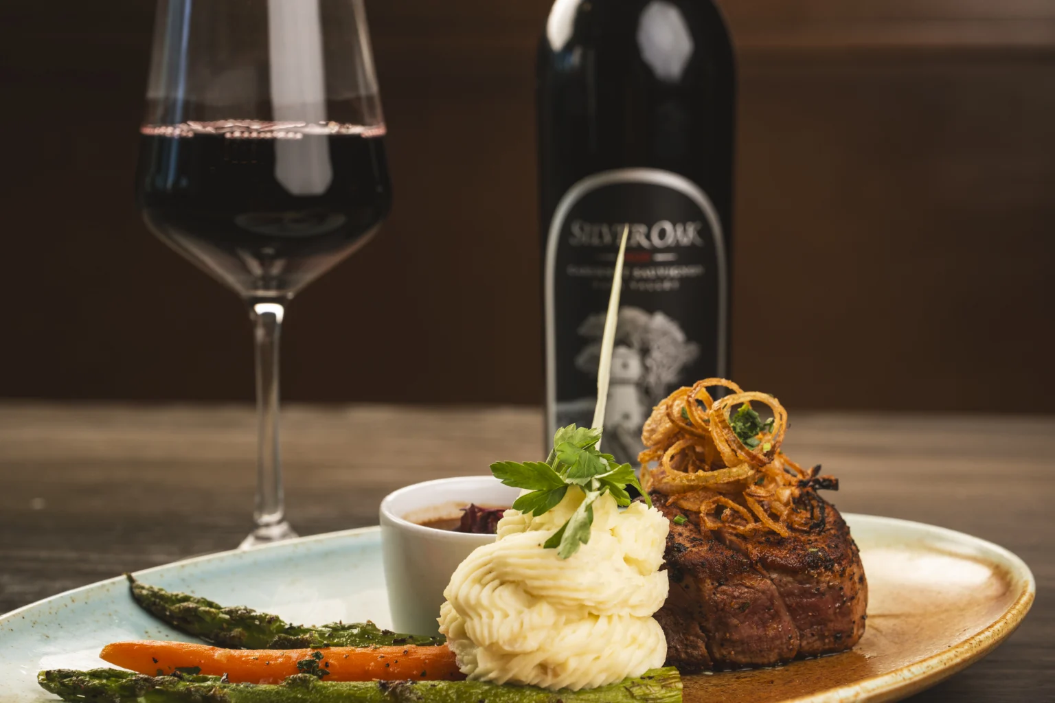 Filet Mignon with a glass and bottle of wine
