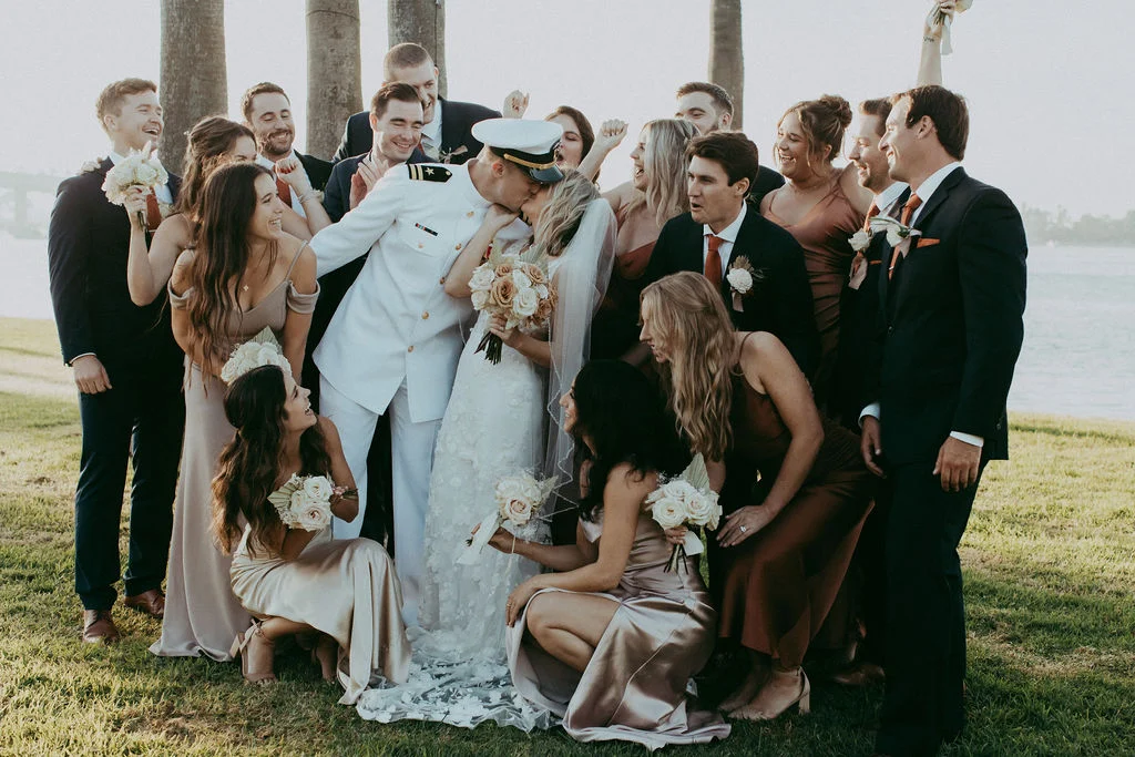 Newlyweds Kissing surrounded by wedding party